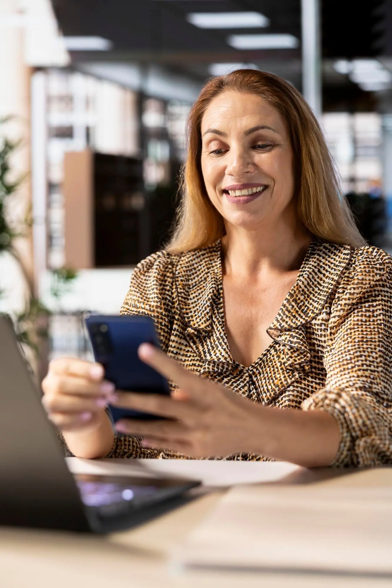 Die Geschäftsführerin nutzt ihr Smartphone, um in sozialen Medien zu surfen und E-Mails zu prüfen.